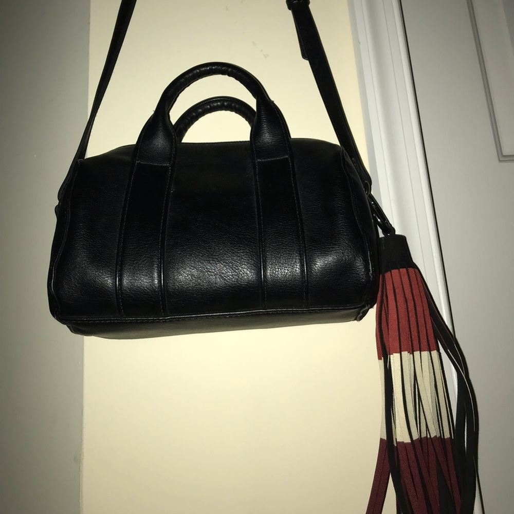 A black cross body with a hanging  accessory